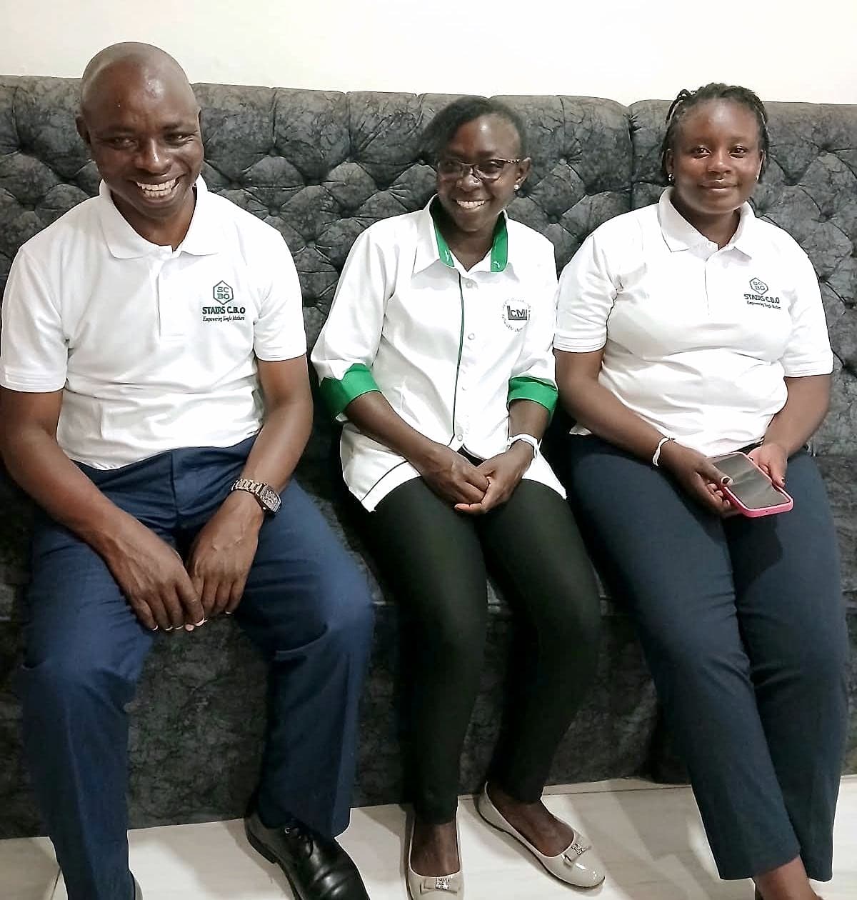 Three members of the STAIRS team, smiling, seated together on a sofa