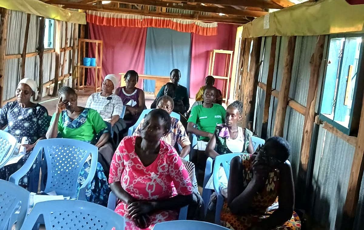 Women seated together listening during a weekly skills training session
